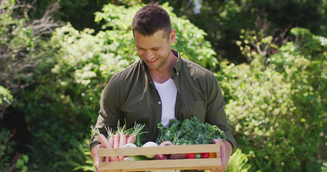 Happy Man Holding Fresh Vegetables in Garden on Sunny Day - Free Images, Stock Photos and Pictures on Pikwizard.com