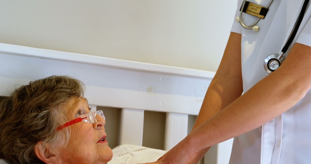 Nurse Comforting Elderly Woman in Hospital Bed - Free Images, Stock Photos and Pictures on Pikwizard.com