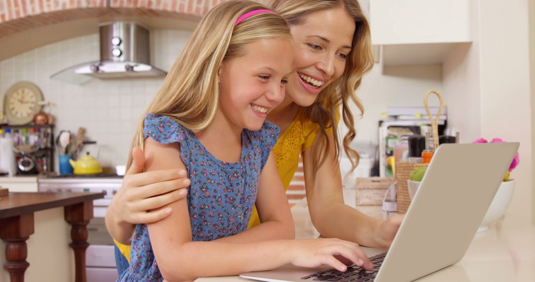 Smiling Mother and Daughter Using Laptop Together in Modern Kitchen - Free Images, Stock Photos and Pictures on Pikwizard.com