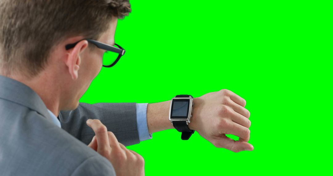 Businessman Checking Smartwatch on Green Background - Free Images, Stock Photos and Pictures on Pikwizard.com