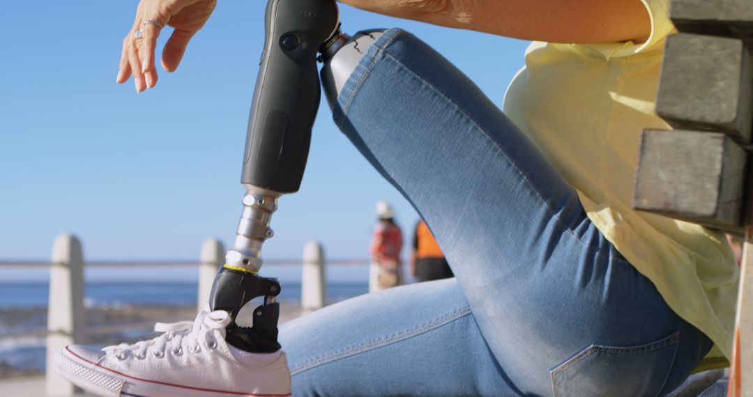 Individual with Prosthetic Leg Enjoying Seaside View on a Sunny Day - Free Images, Stock Photos and Pictures on Pikwizard.com