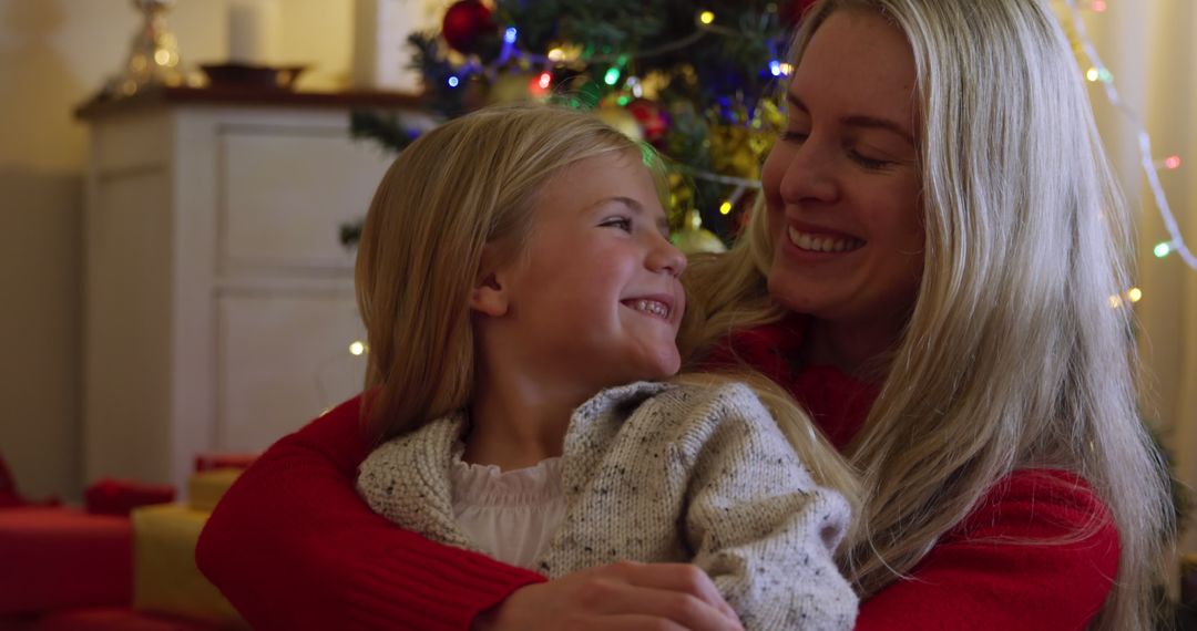 Mother and Daughter Embracing Joyfully by Christmas Tree - Free Images, Stock Photos and Pictures on Pikwizard.com