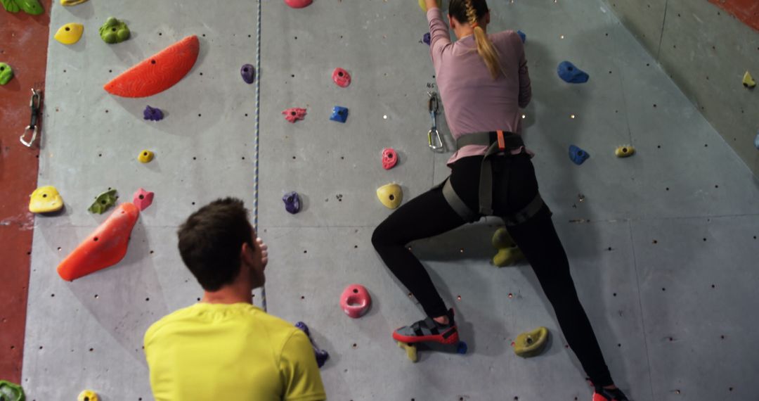 Woman Climbing Indoor Rock Wall with Instructor - Free Images, Stock Photos and Pictures on Pikwizard.com