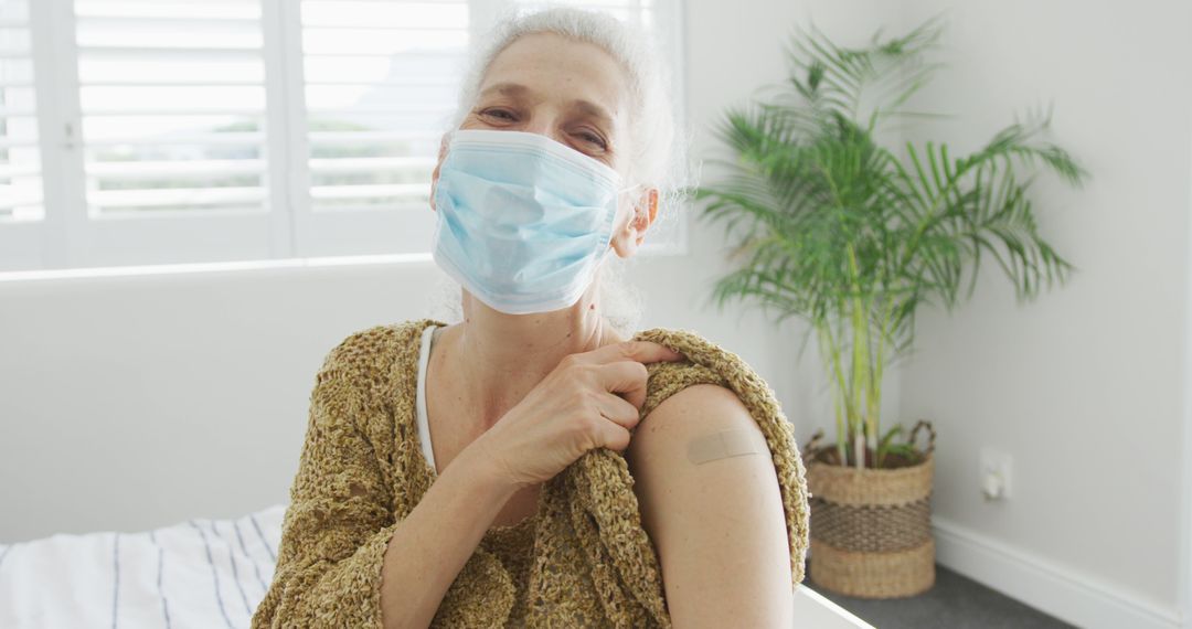 Elderly Woman Wearing Face Mask Showing Arm After Vaccination at Home - Free Images, Stock Photos and Pictures on Pikwizard.com