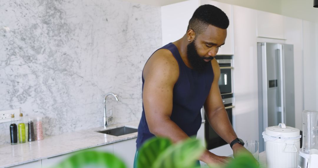 Man Preparing Meal on Modern Kitchen Counter with Blender