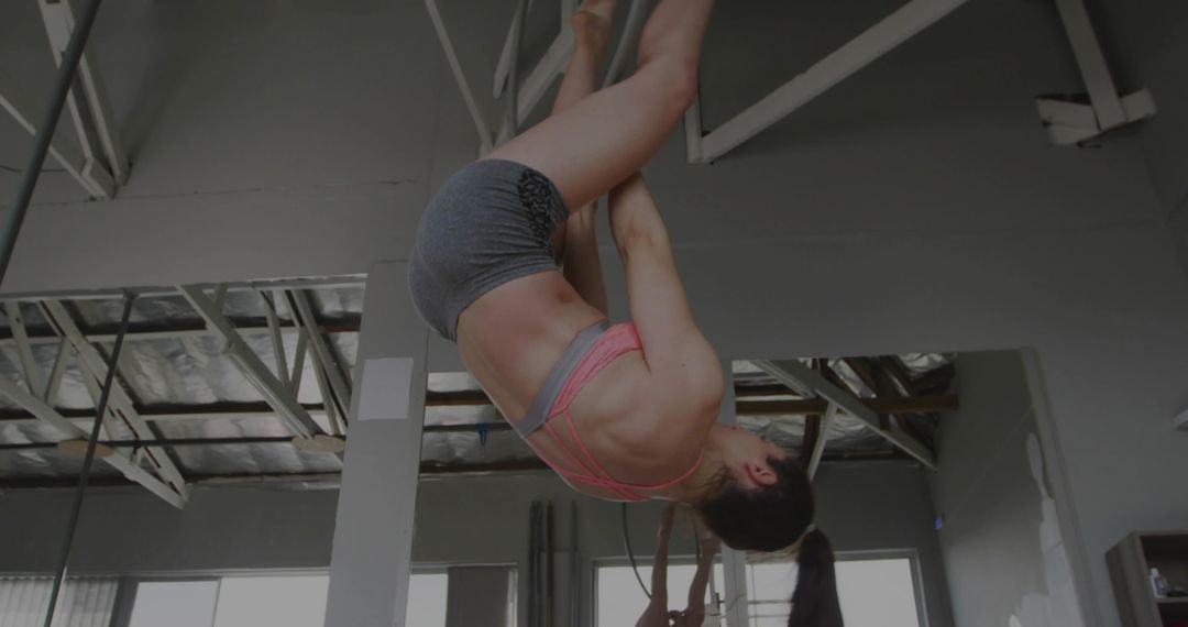 Acrobatic Dancer Demonstrating Inverted Pole Fitness Move