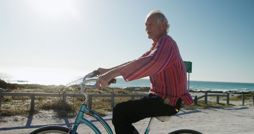 Senior Man Riding Bicycle on Sunny Beach Path - Free Images, Stock Photos and Pictures on Pikwizard.com