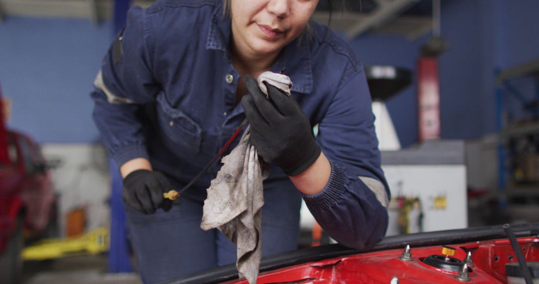 Female Automotive Mechanic Checking Dipstick for Oil Maintenance - Free Images, Stock Photos and Pictures on Pikwizard.com