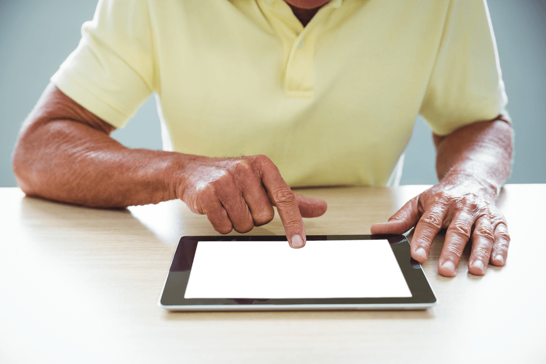 Senior Man Using Transparent Tablet Touchscreen Indoors