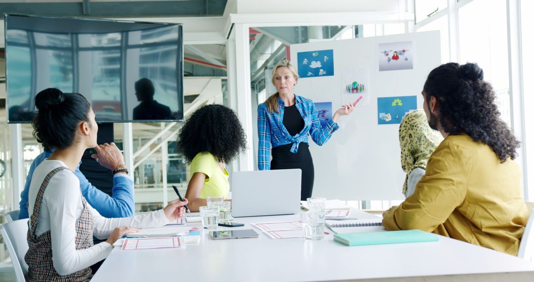 Businesswoman Presenting to Diverse Team in Modern Office - Free Images, Stock Photos and Pictures on Pikwizard.com