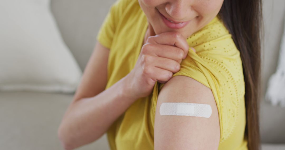 Woman Proudly Displaying Arm with Bandage After Vaccination - Free Images, Stock Photos and Pictures on Pikwizard.com