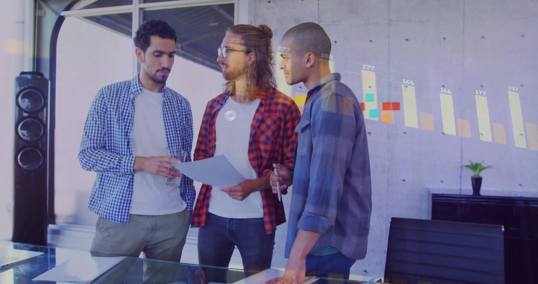 Three Young Professionals Collaborating with Projected Bar Graph in Office