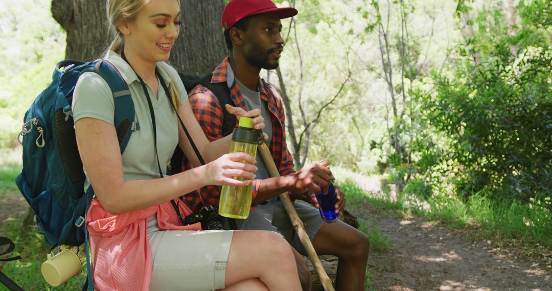 Happy Couple Resting with Backpacks in Sunny Park