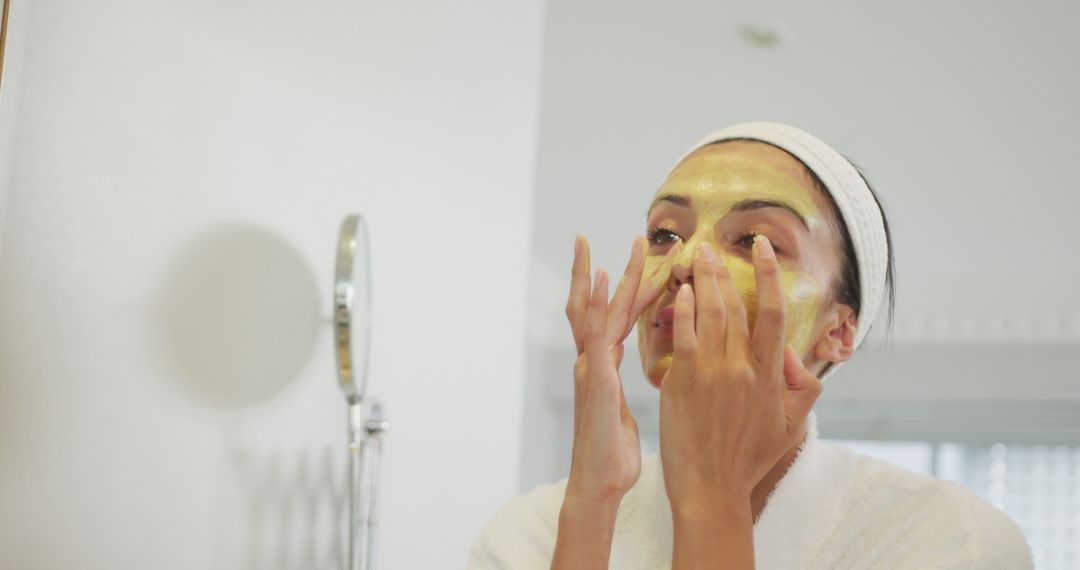 Caucasian Woman Applying Face Mask in Bathroom Mirror - Free Images, Stock Photos and Pictures on Pikwizard.com