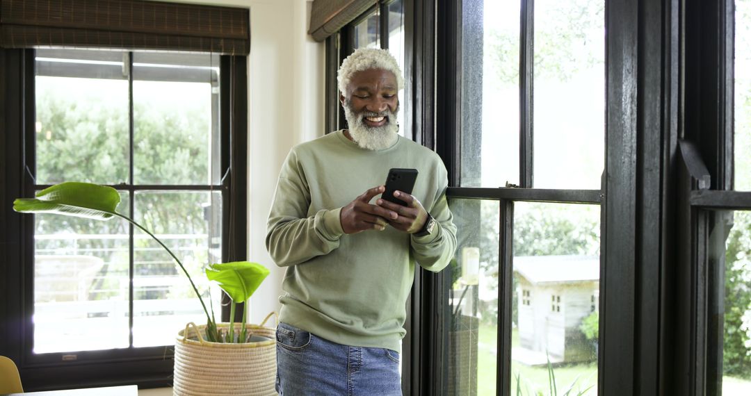Elderly Man in Mint Sweater Using Smartphone Indoors