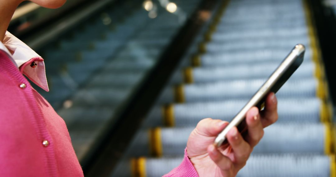 Person Using Smartphone on Escalator in Modern Building - Free Images, Stock Photos and Pictures on Pikwizard.com