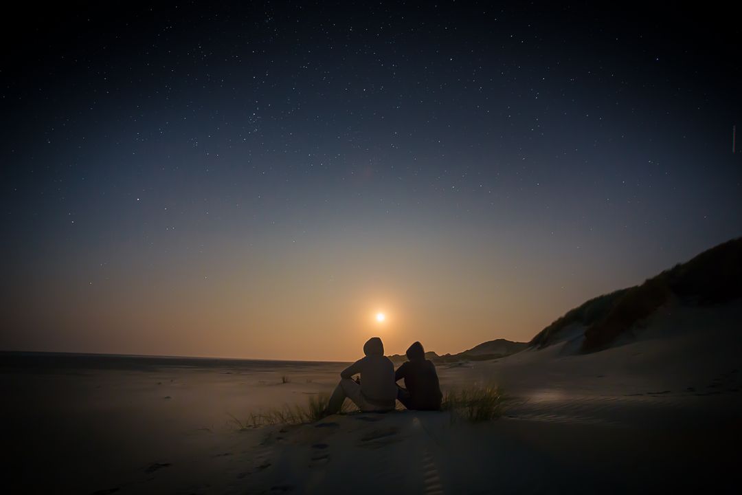 Couple Watching Sunset on Sand Dunes with Starry Sky - Free Images, Stock Photos and Pictures on Pikwizard.com