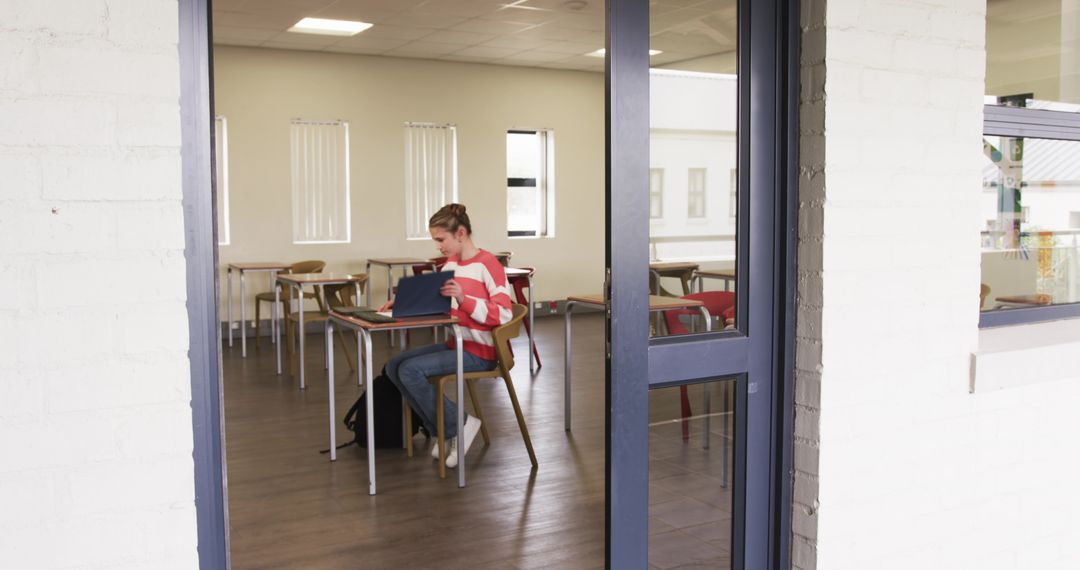Girl Engaged with Tablet in Empty Classroom Setting