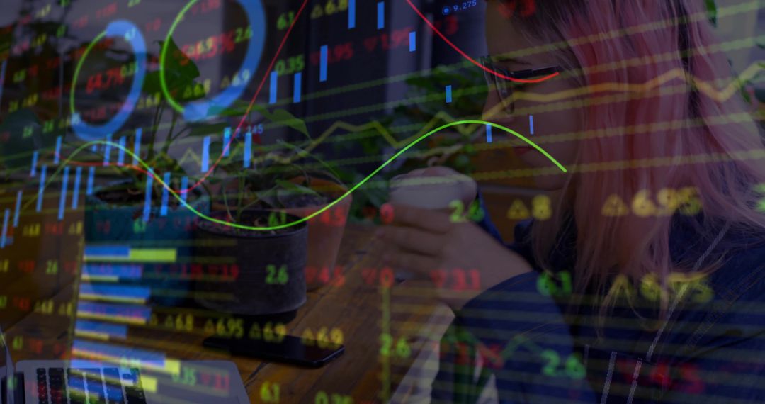 Remote trader analyzing market charts while sipping coffee in coworking café with laptop