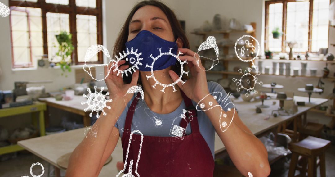 Woman with Face Mask in Workshop During Pandemic with Virus Icons Overlay