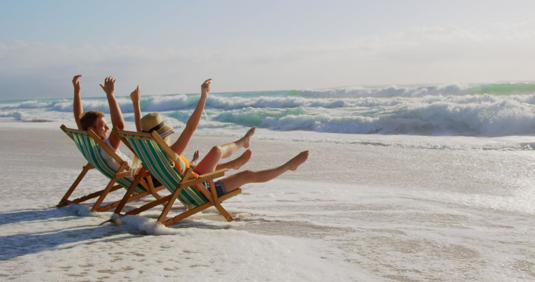 Young Couple Enjoying Seaside with Chairs and Waves