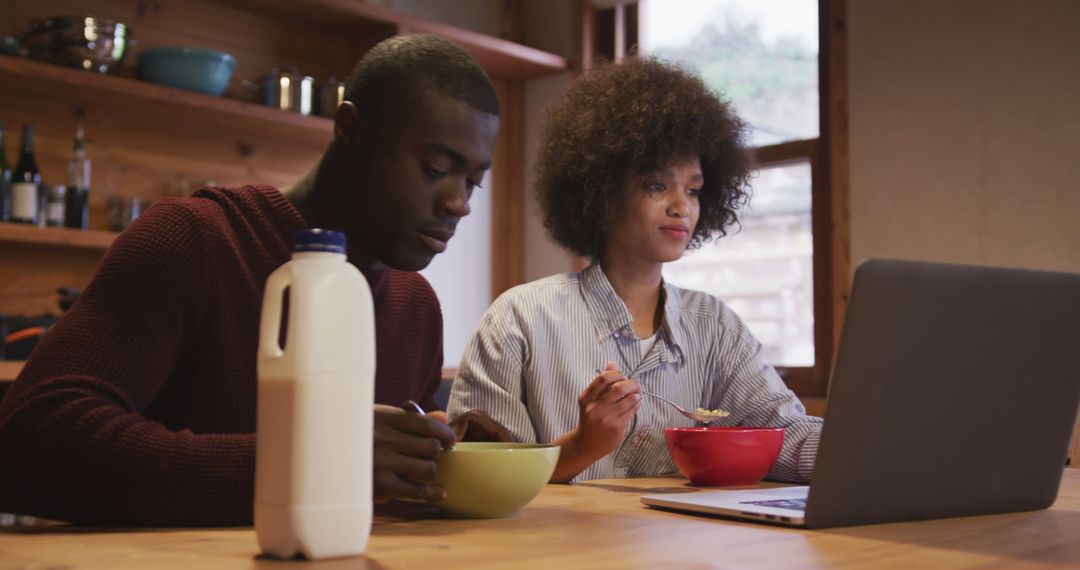 Young Couple Enjoying Breakfast While Working from Home on Laptop
