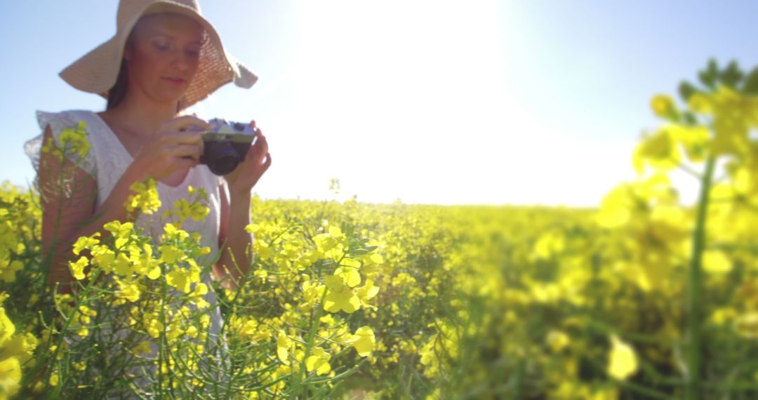 Woman Capturing Memories in Sunny Mustard Field - Free Images, Stock Photos and Pictures on Pikwizard.com