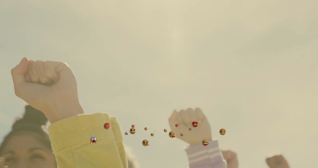 Women Raising Fists in Unity with Floating Emojis