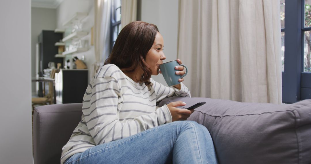 Woman Relaxing with Coffee and Remote Control at Home - Free Images, Stock Photos and Pictures on Pikwizard.com