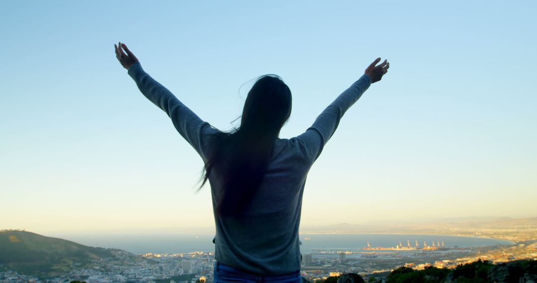 Woman Celebrating Overlooking Cityscape by the Sea - Free Images, Stock Photos and Pictures on Pikwizard.com