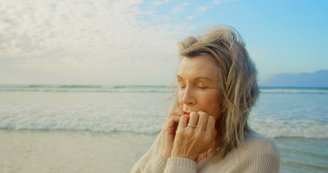 Senior Woman With Eyes Closed Standing on Windy Beach