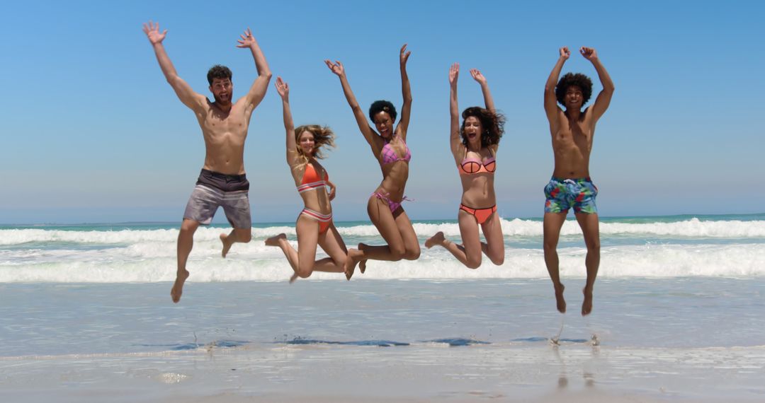 Group of Friends Jumping on Beach Having Fun Under Sunny Sky - Free Images, Stock Photos and Pictures on Pikwizard.com