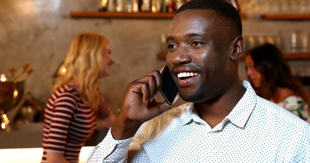 Smiling Man Talking on Phone in Modern Casual Cafe - Free Images, Stock Photos and Pictures on Pikwizard.com