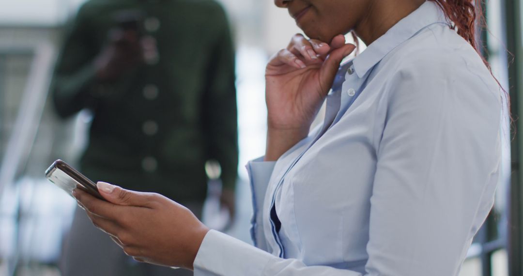 Confident Professional Using Smartphone in Modern Office