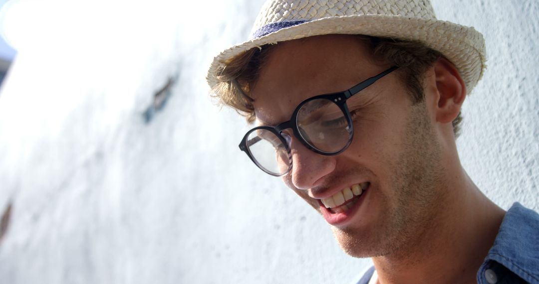 Smiling Young Man Wearing Glasses and Straw Hat Outdoors - Free Images, Stock Photos and Pictures on Pikwizard.com