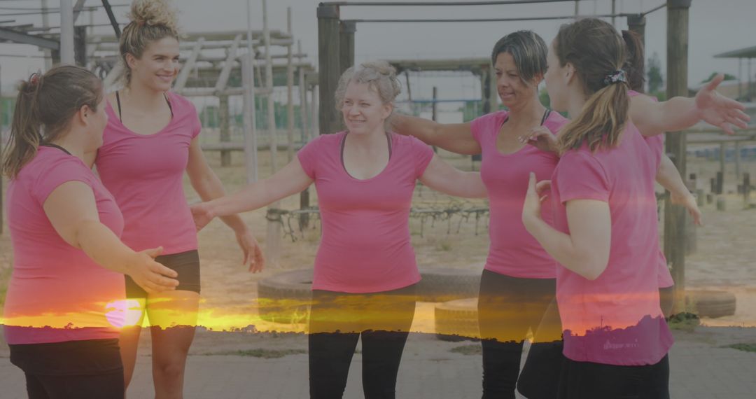 Unity and Fitness: Women Embracing at Obstacle Course at Sunset