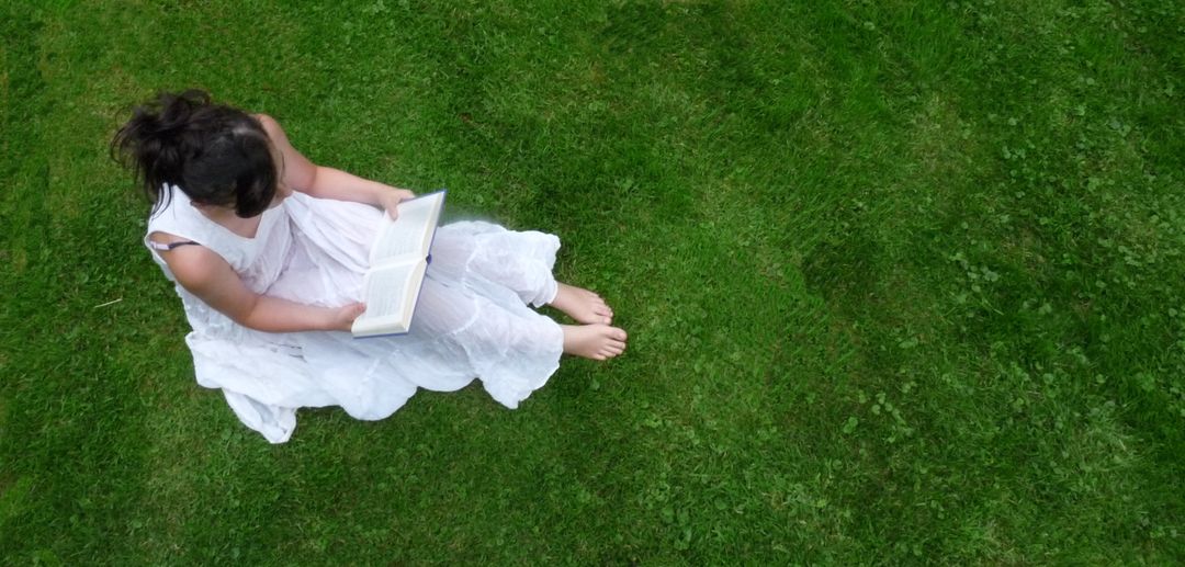 Woman Reading Book on Grass in White Dress Aerial View - Free Images, Stock Photos and Pictures on Pikwizard.com