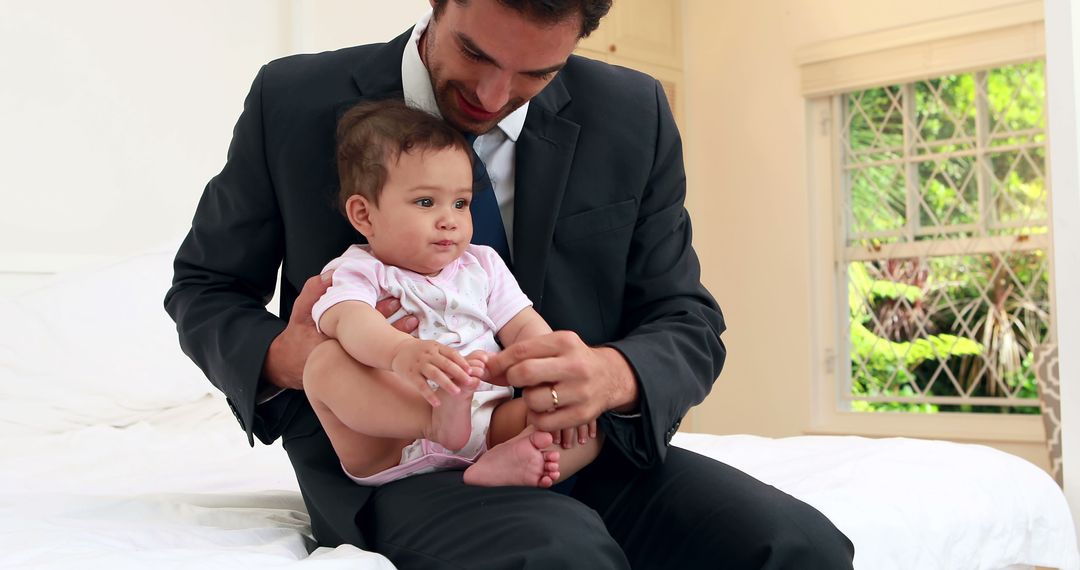 Businessman Holding Baby in Bedroom - Free Images, Stock Photos and Pictures on Pikwizard.com