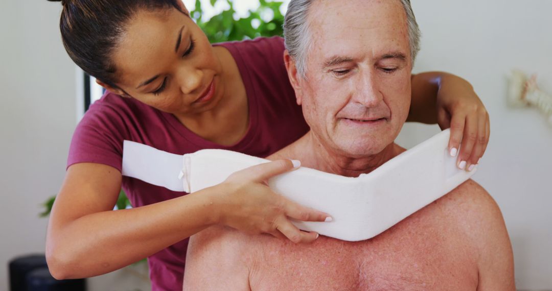 Female Caregiver Applying Neck Brace to Senior Man at Home - Free Images, Stock Photos and Pictures on Pikwizard.com