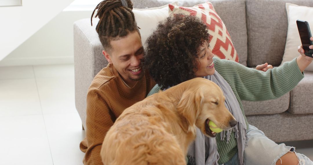 Couple taking selfie with golden retriever in cozy living room, smiling and playful