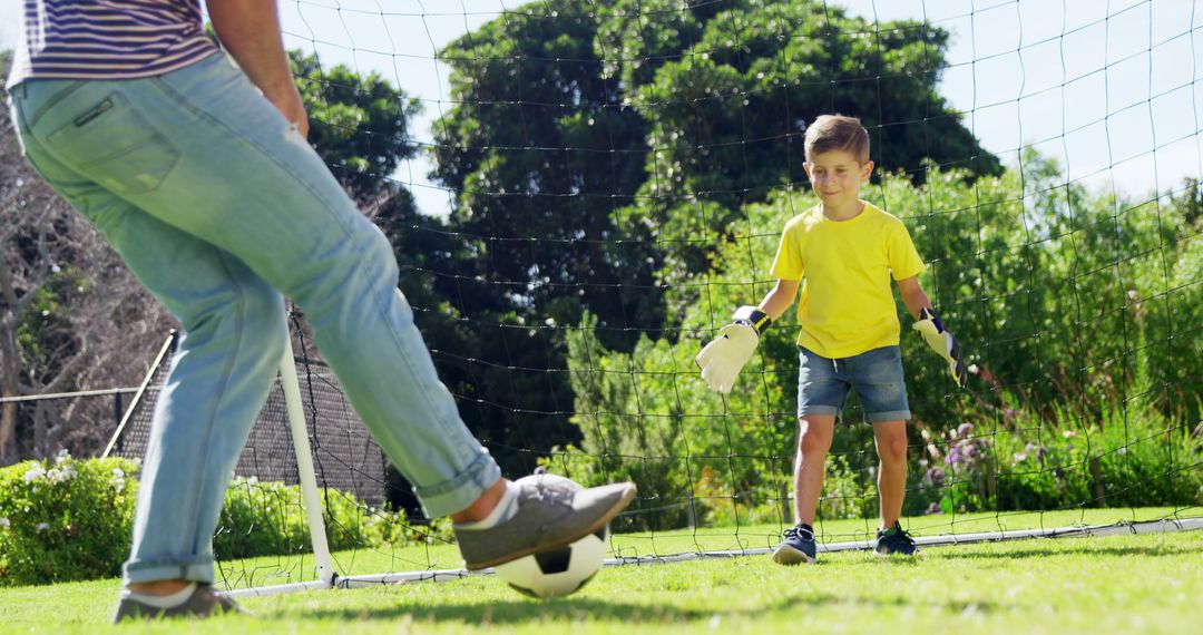 Father and Son Playing Soccer in Sunny Backyard - Free Images, Stock Photos and Pictures on Pikwizard.com