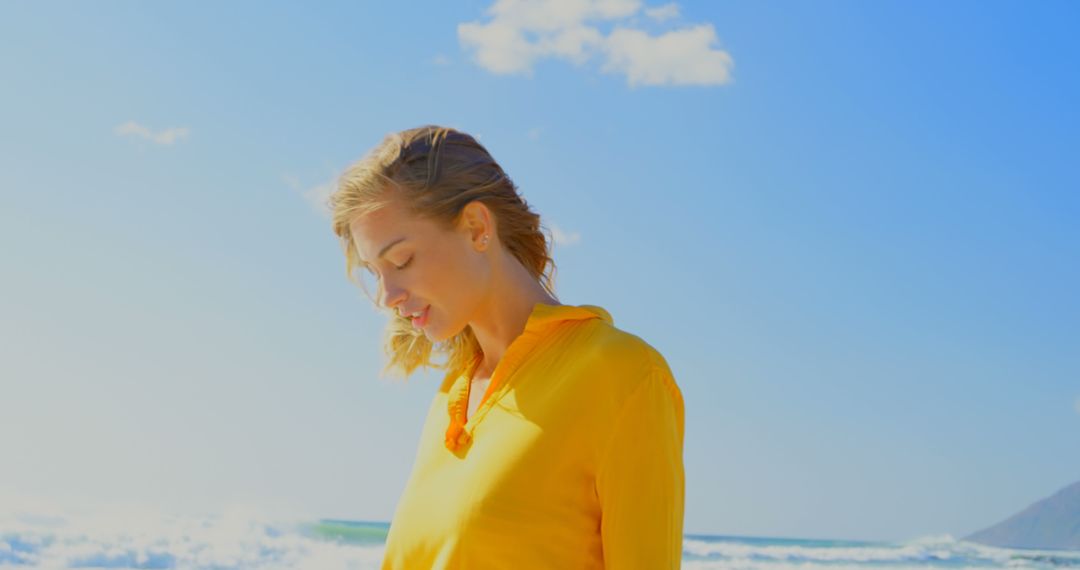 Tranquil Moment of Young Woman In Yellow Shirt on Beach - Free Images, Stock Photos and Pictures on Pikwizard.com