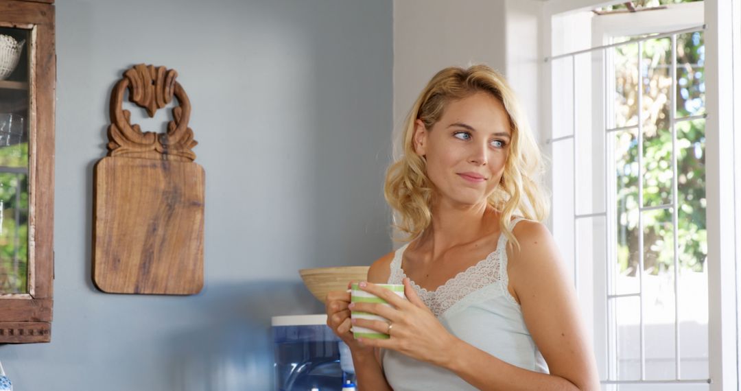 Cheerful Woman Drinking Coffee in Bright Kitchen - Free Images, Stock Photos and Pictures on Pikwizard.com