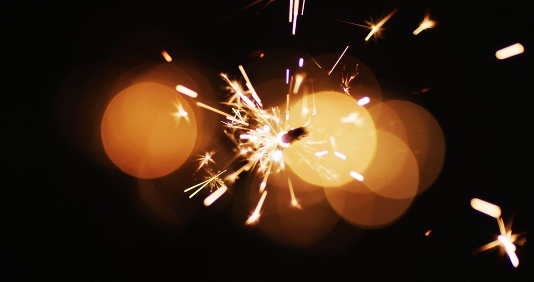 Close-Up of Sparkler with Glowing Sparks Against Black Background