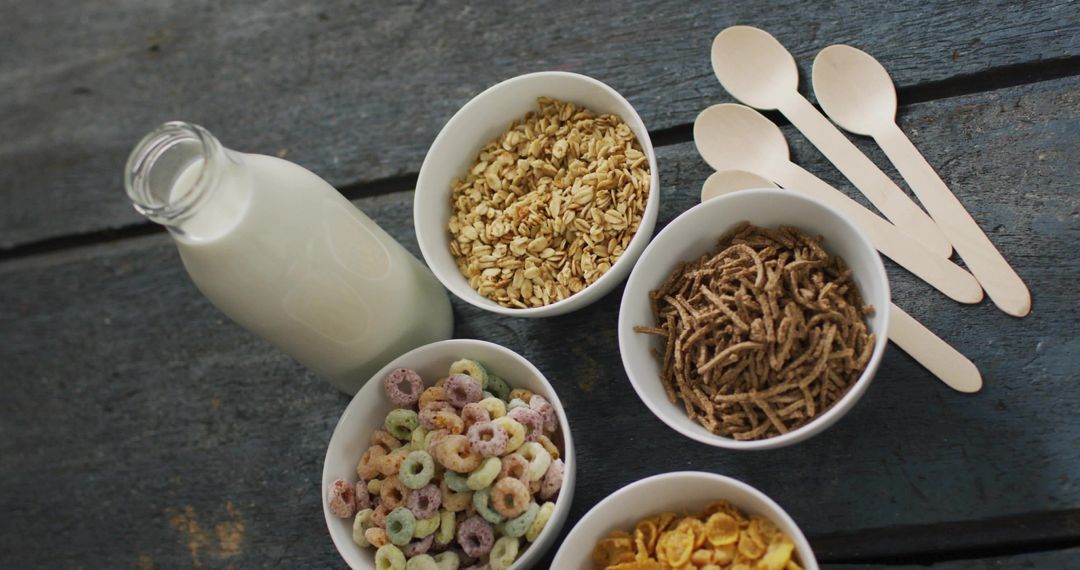 Displaying Rustic Breakfast Cereal Variety with Milk Bottle and Wooden Spoons Flatlay