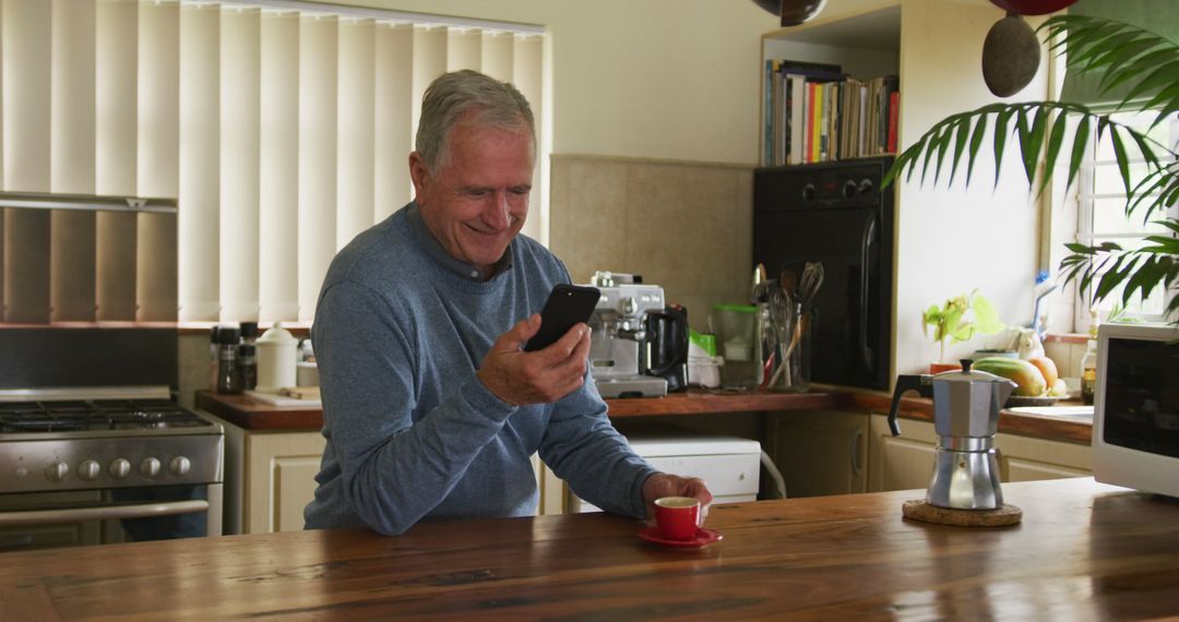 Senior Man Enjoying Morning Coffee in Kitchen While Using Smartphone - Free Images, Stock Photos and Pictures on Pikwizard.com