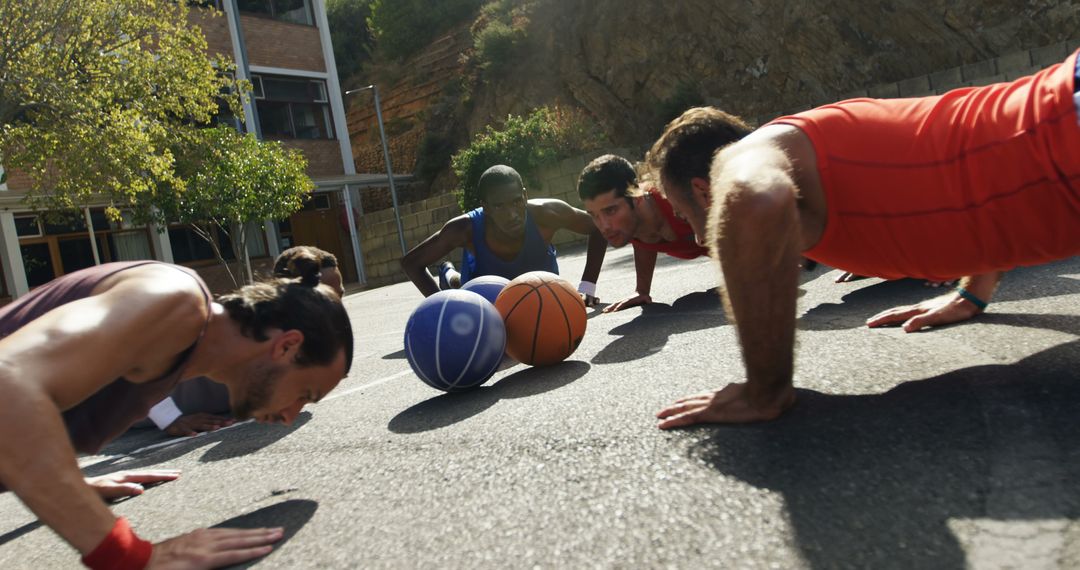 Athletes Doing Push-Ups Outdoors Near Basketballs on Sunny Day - Free Images, Stock Photos and Pictures on Pikwizard.com