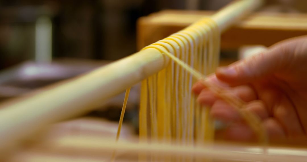 Hand Holding Freshly Made Pasta Hanging to Dry - Free Images, Stock Photos and Pictures on Pikwizard.com