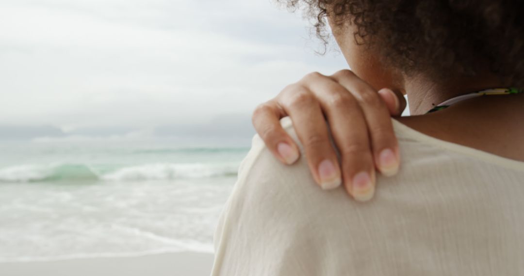 Woman Relaxing on Beach Holding Shoulder Close-Up View - Free Images, Stock Photos and Pictures on Pikwizard.com