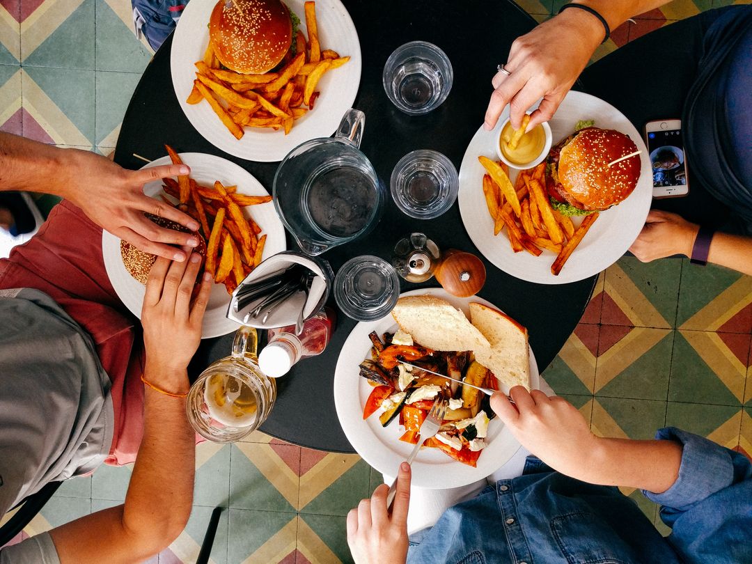 Friends Enjoying Burgers and Fries at Cafe Table